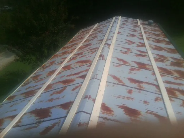 Rusted metal roof panels with new wood purlins before replacement — Storm Damage Roof Repair in Mc Gill by Roofing Brothers