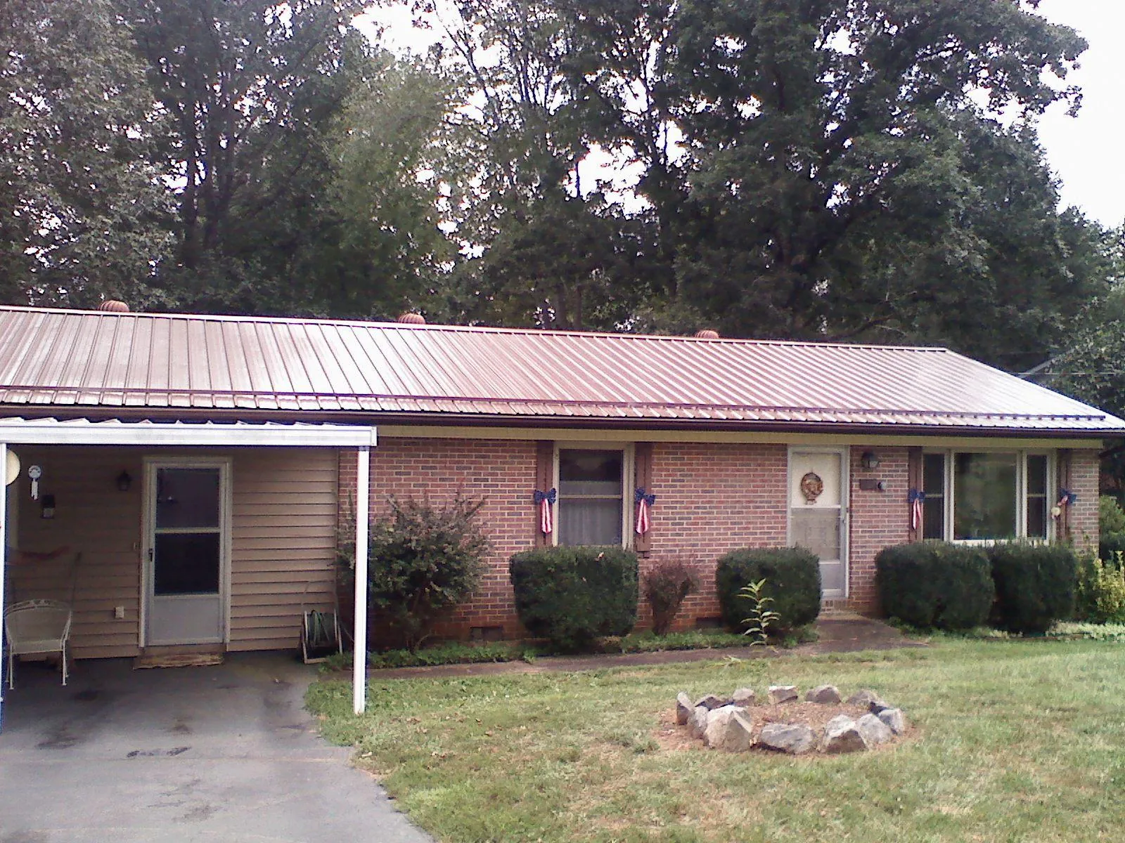 Bronze metal roof and carport on a brick ranch home — Roof Repair work by our crew in Mc Gill